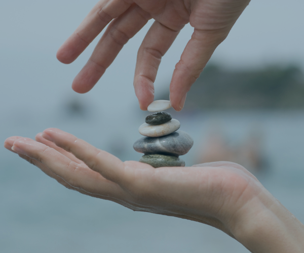 Hände setzen Steine aufeinander